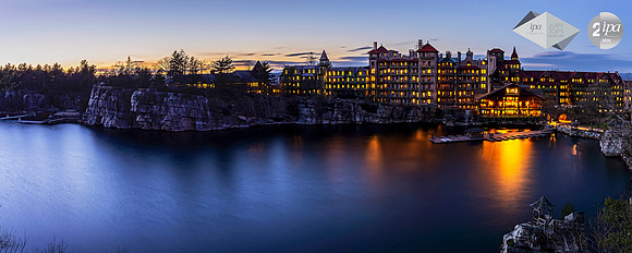Panoramic photograph of the historic Mohonk Mountain House and lake at sunset with a long exposure