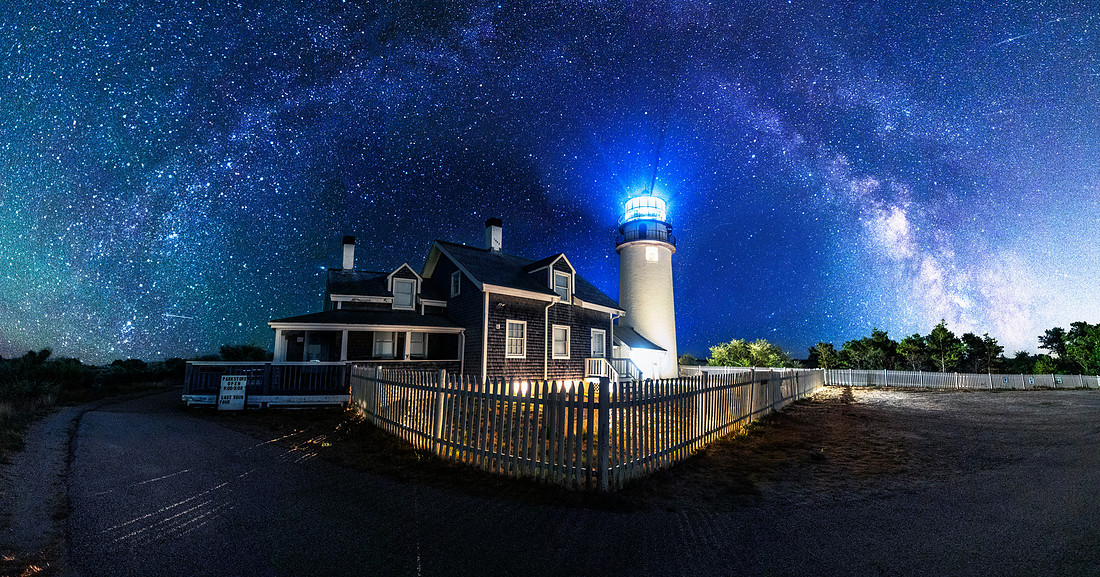 Lighthouse on Cape Cod in Massachusetts called Highland Light or Cape Cod Light with the Milky Way arch rising above