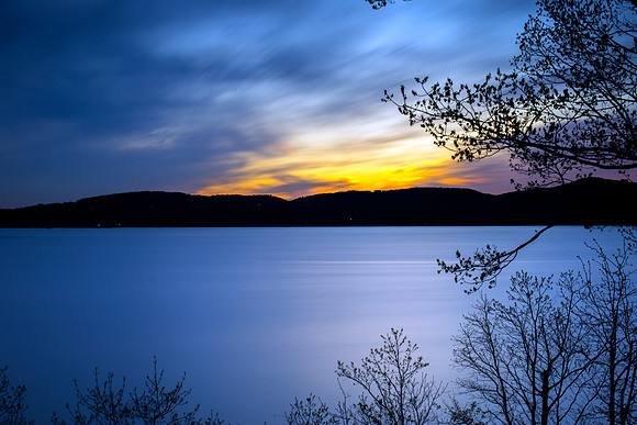 Long Exposure photograph of the Hudson River at sunset in summer 2017 in Sleepy Hollow, New York Hudson Valley with mountains, night sky and clouds