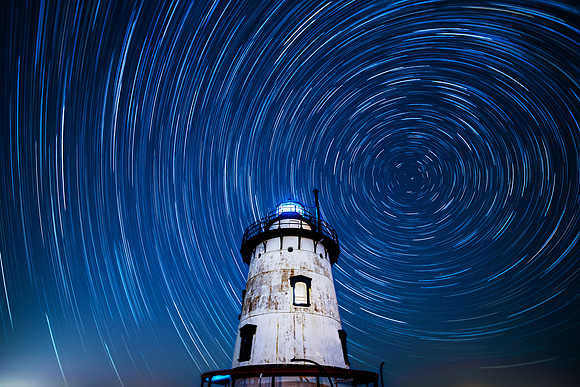 Long exposure creating star trails in the night sky above the Tarrytown/Sleepy Hollow Lighthouse on the Hudson River in Sleepy Hollow, NY Hudson Valley, Westchester County