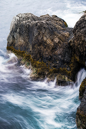 Long Exposure shot of rough seas hitting a large rock of the famous Newport, RI Cliffwalk
