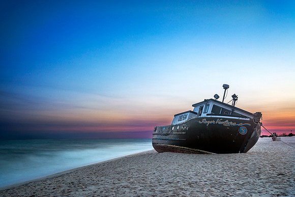 Shipwreck on beach with sunset blue and pink sky and the Atlantic Ocean