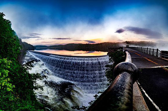 New Croton Dam and Reservoir during sunset in spring 2022 with clouds and foliage and flowing water following a spring storm